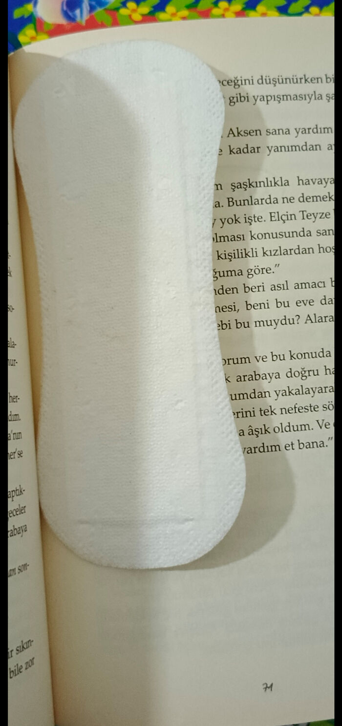 Book lovers use a unique bookmark with a white pad on an open book page.