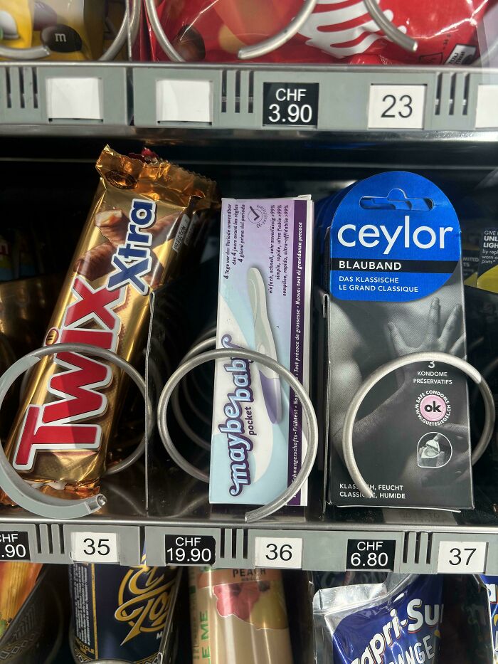Productos ingeniosos en máquina expendedora: barra de chocolate, prueba de ovulación y preservativos.