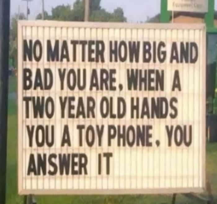 Parenting meme sign humorously highlighting interactions with toddlers and toy phones.
