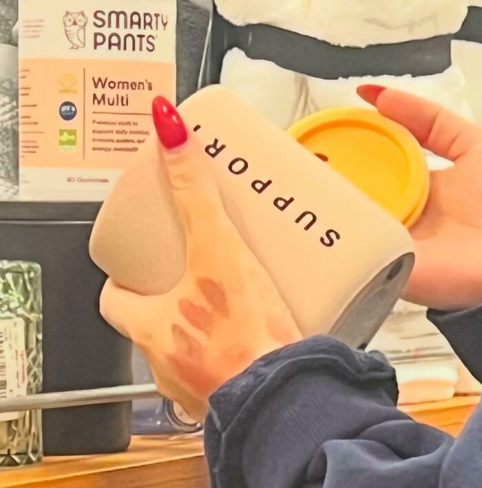 Person with red nails holding a supplement jar labeled "SUPPDR." in a store, showing entitled behavior.