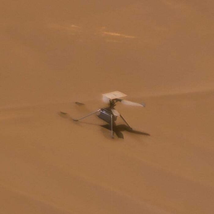 Small helicopter on desert terrain, highlighting its super expensive technology in harsh conditions.