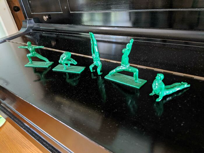 Green toy soldiers doing yoga poses, a unique home discovery.
