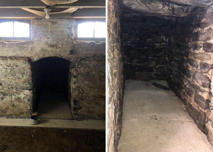 Stone-walled home discovery finds a hidden cellar with a small arched entrance, partially lit by natural light.