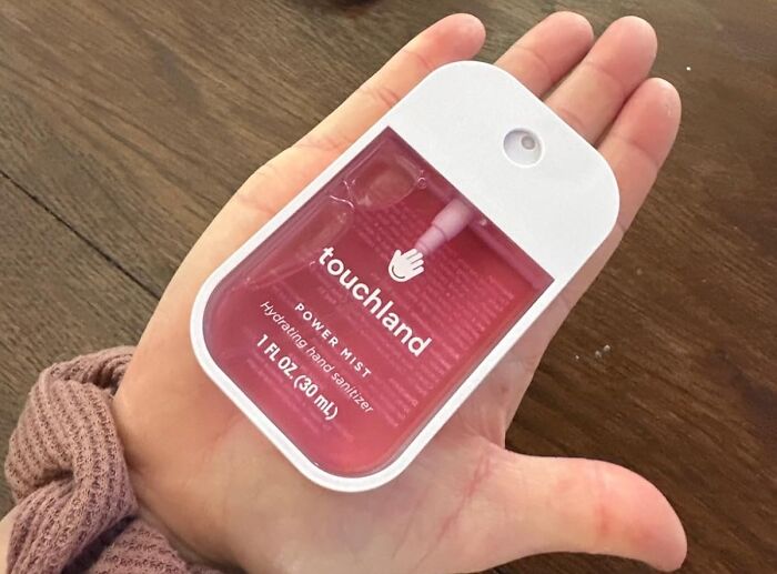 Hand holds a pink Touchland Power Mist hand sanitizer, a wished-for item for personal care.