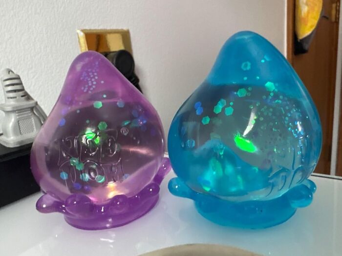 Colorful decorative items on a shelf, featuring purple and blue sparkles.