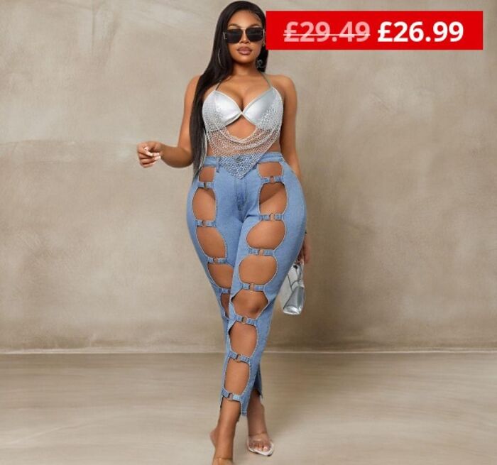 Woman in cut-out jeans and metallic top posing indoors, showcasing a fashion disaster.