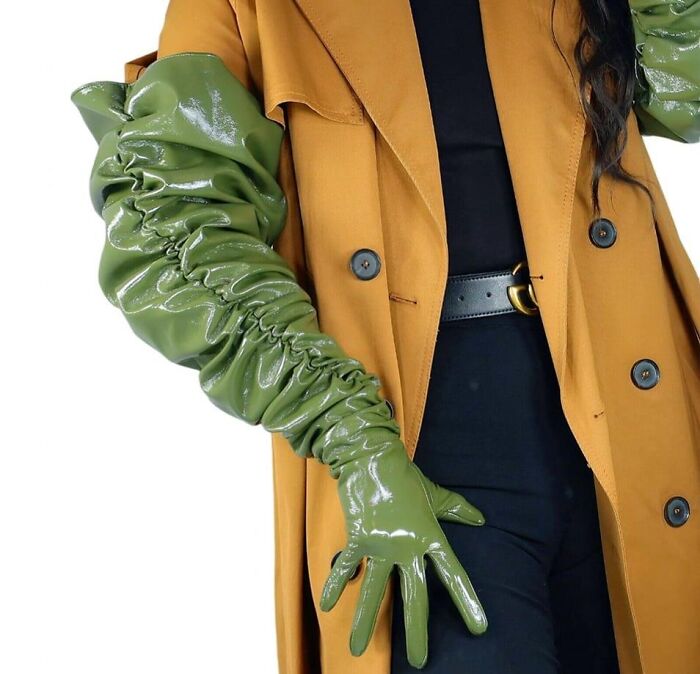 Fashion disaster with oversized green vinyl gloves and mustard coat.