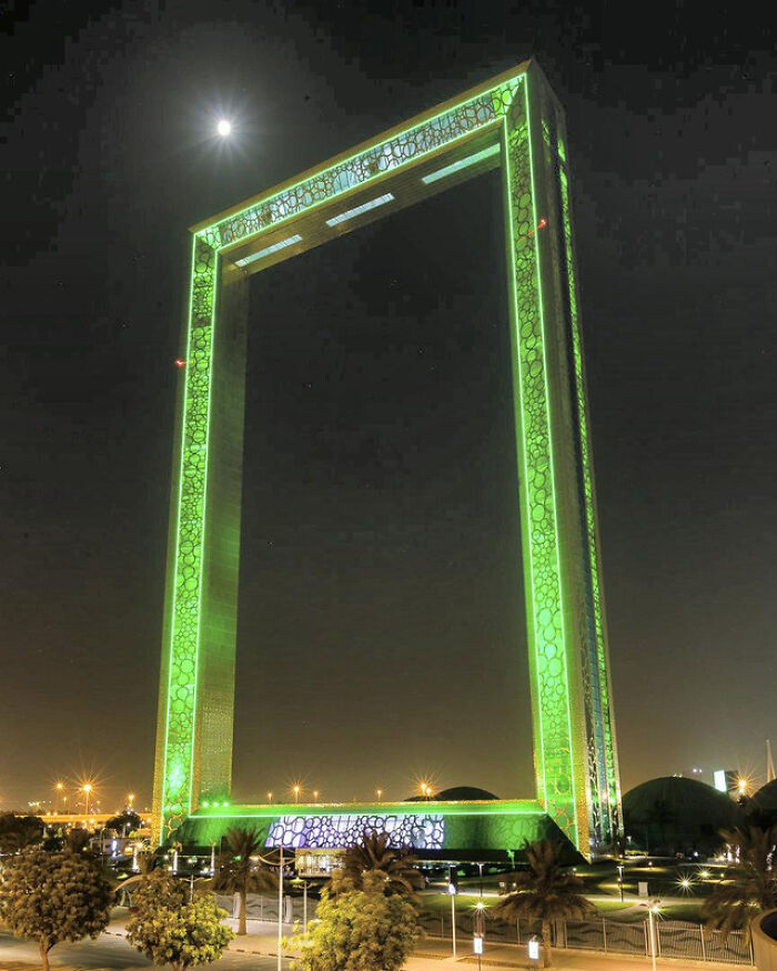 Illuminated Dubai Frame at night with a glowing green design, showcasing unique architecture.