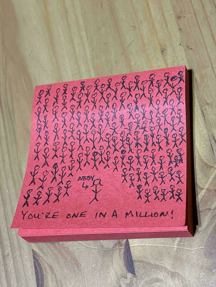 Drawing of stick figures on red paper with the phrase "You're one in a million!" written below, highlighting a dad's sentiment.