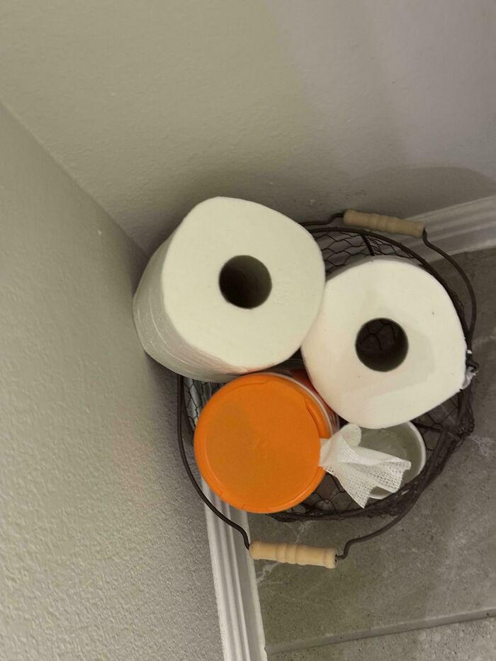 A basket with two toilet rolls and a container, resembling a playful face, showcasing dad's creativity.