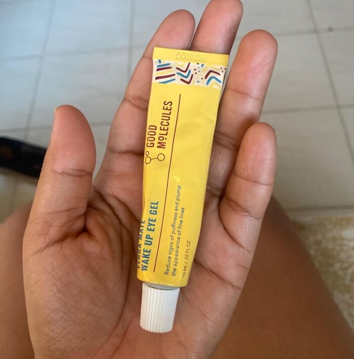 Hand holding a tube of eye gel from a small business on Amazon.