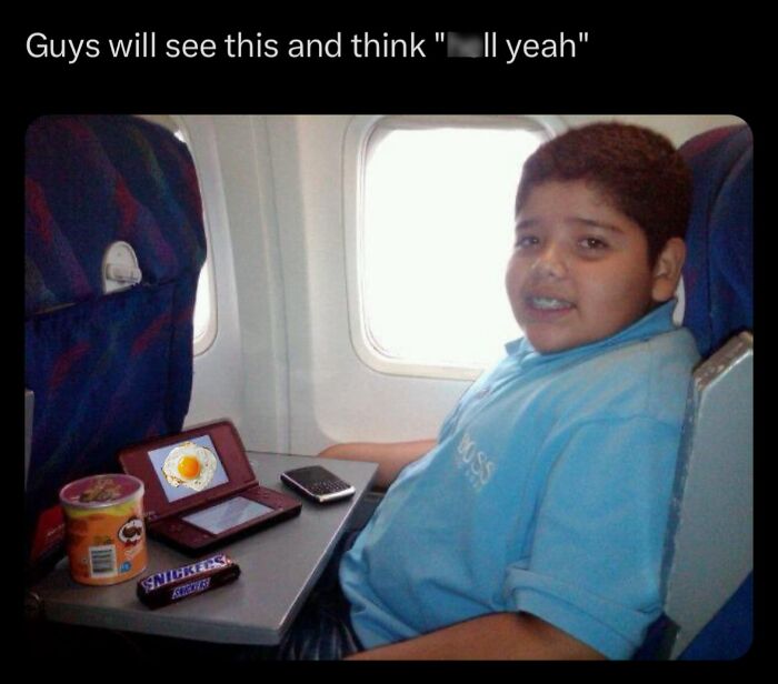 Young boy enjoying snacks and playing games on a flight; funny memes theme.