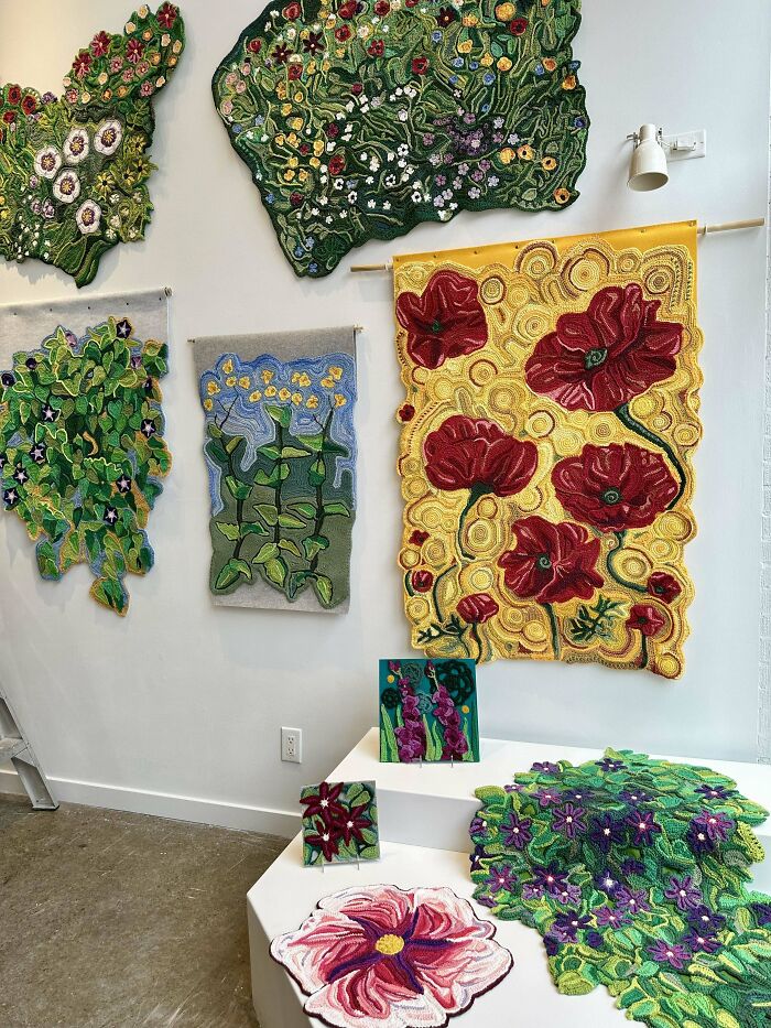 Intricate crochet floral wall hangings and art pieces displayed in a bright gallery showcasing creative crochet enthusiasts' work.