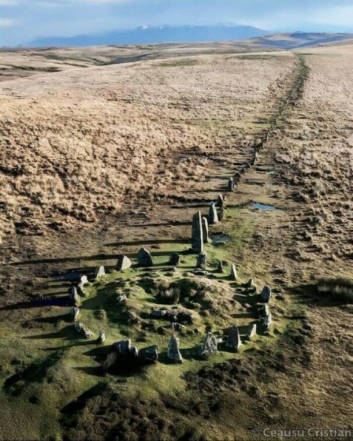 Ancient stone circle and pathway in a vast landscape, showcasing preserved items from past explorations.