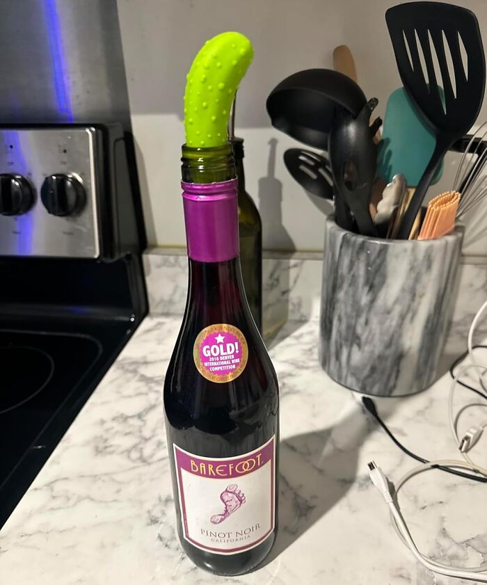 Genuine Fred wine stopper shaped like a cactus in a Pinot Noir bottle on a kitchen counter.
