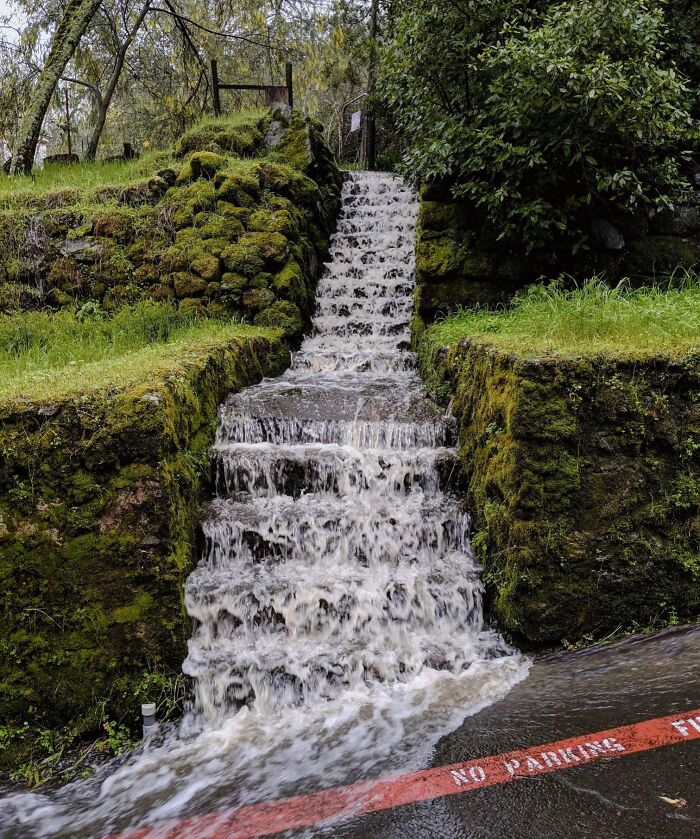 Water cascades down moss-covered steps, showcasing nature's powerful force.