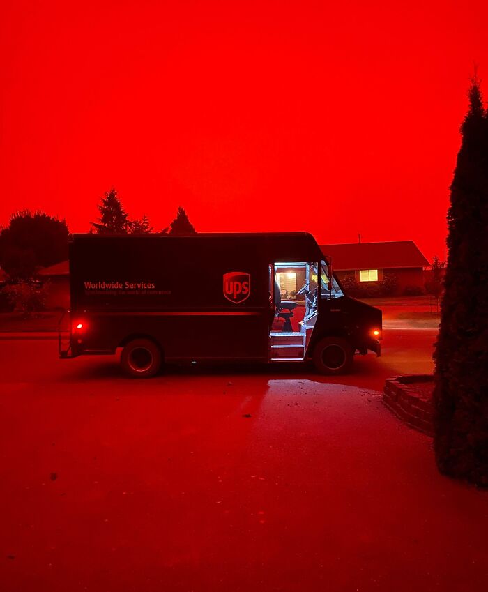 UPS truck under a fiery red sky, showcasing nature's powerful and terrifying spectacle.