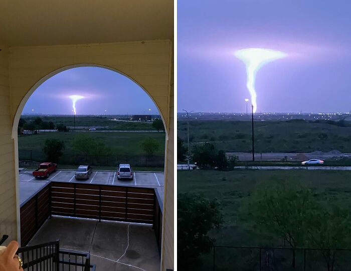 A powerful lightning bolt illuminates the night sky over a distant landscape, showcasing nature's terrifying force.