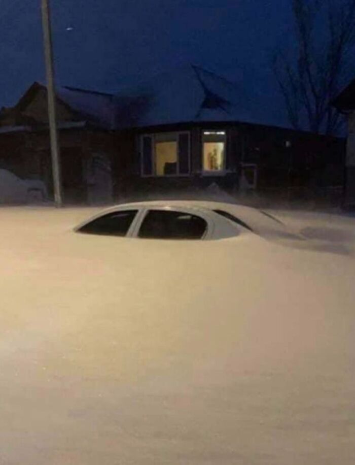 Car buried in deep snow, showcasing nature's powerful and terrifying force.