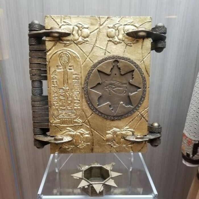Ancient explorers artifact with intricate designs and hieroglyphs displayed on a stand.