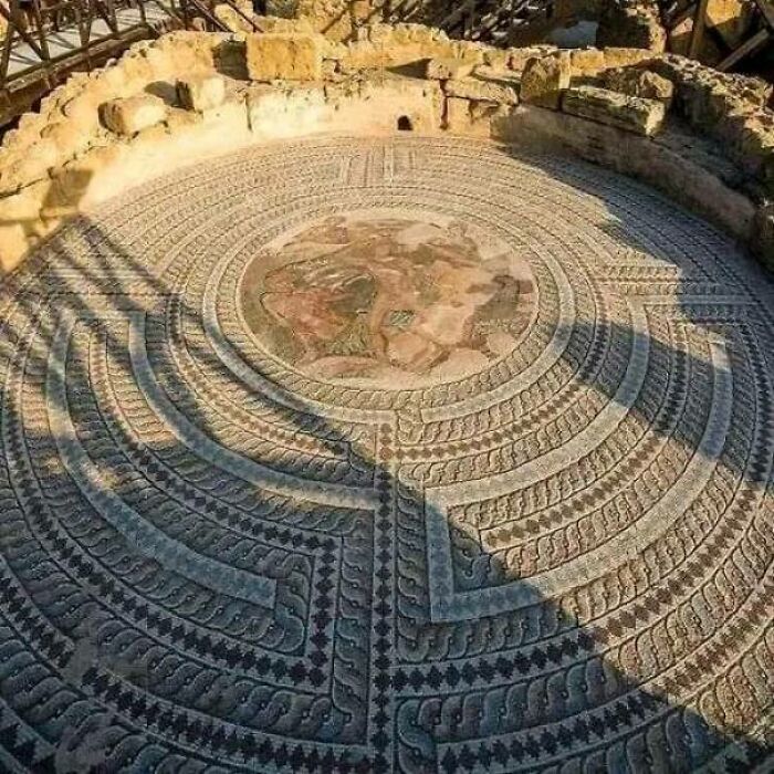 Ancient mosaic pattern in a circular formation, showcasing intricate designs from past explorers.