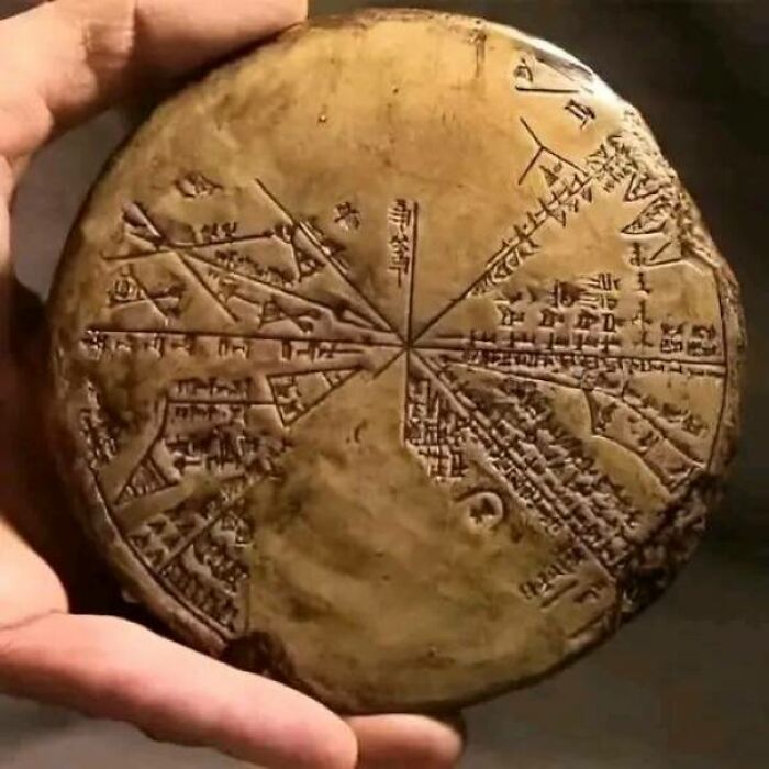 Ancient explorers artifact featuring inscriptions on a round tablet, held in hand, showcasing preserved historical details.