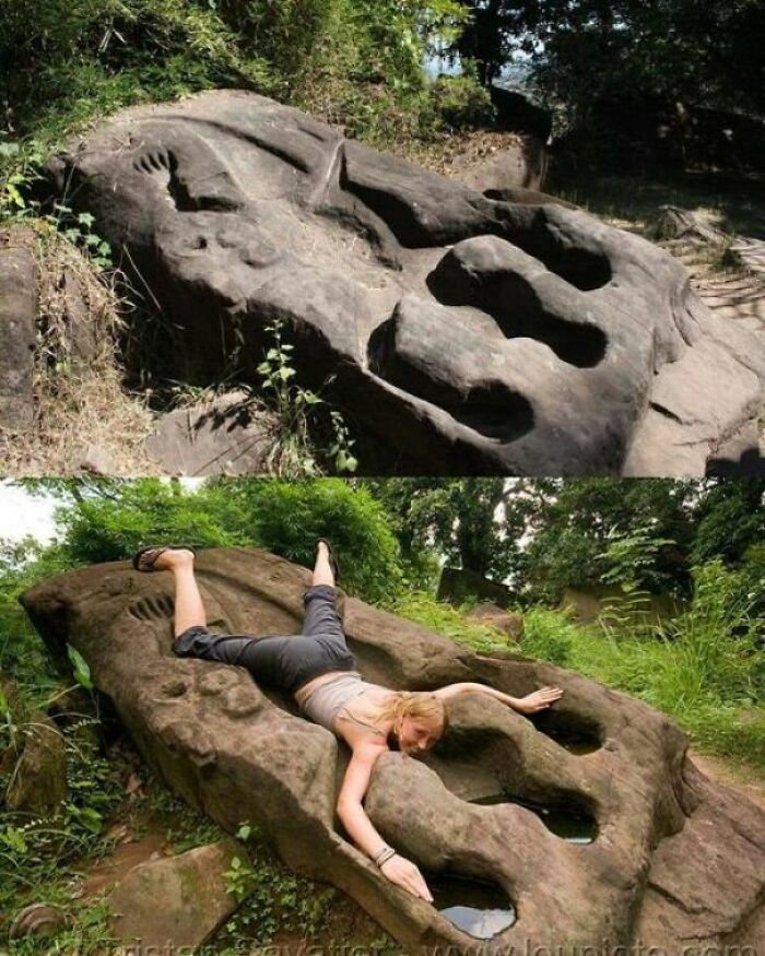 Ancient explorers marvel at giant stone carvings, with a person lying on one for scale.
