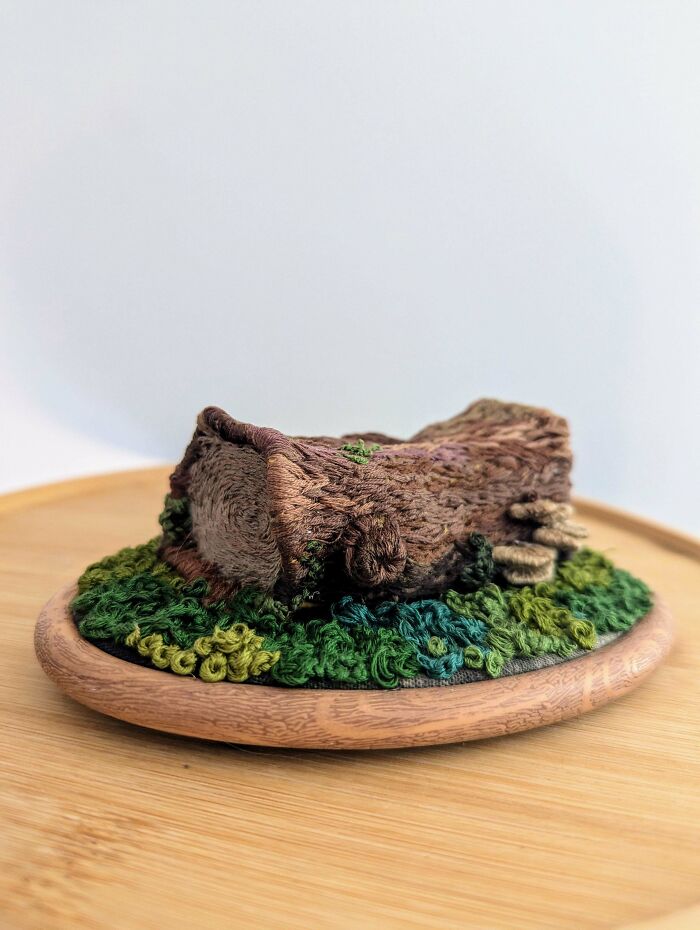 3D embroidered tree stump and grass on a wooden base showcasing incredible and beautiful embroidery skills.