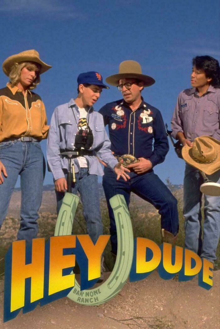 Cast of Hey Dude standing outdoors with hats and cowboy outfits, capturing nostalgic 90s television moments and style.