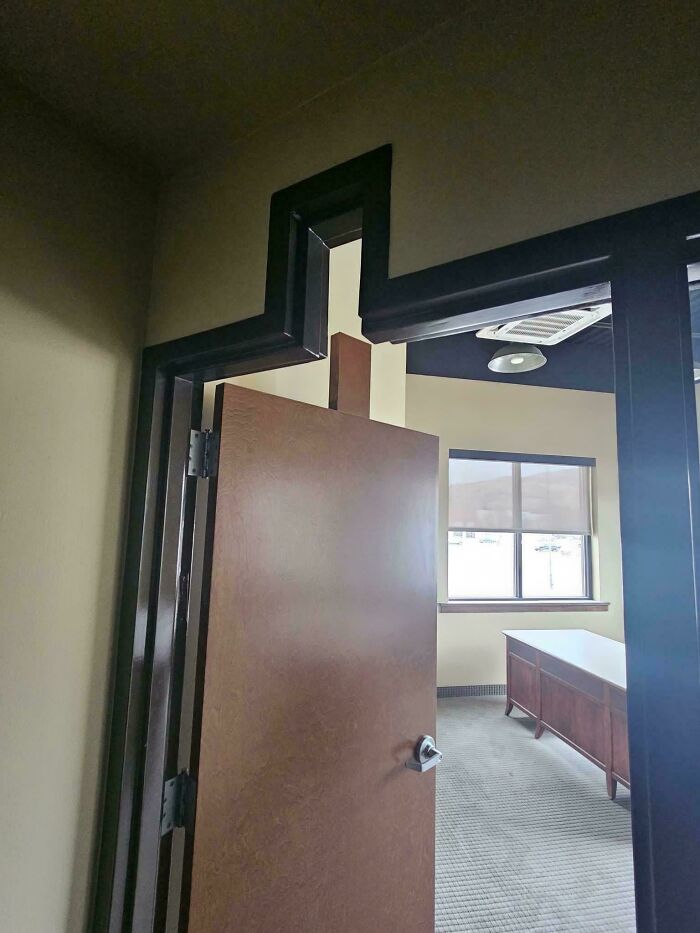 Door with an unusual jagged frame design causing a DIY disaster in an interior space with beige walls and carpet.