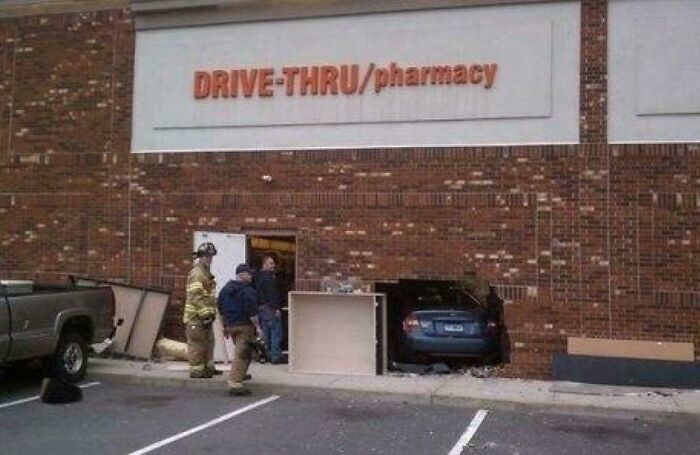 A car crashed into a drive-thru pharmacy building, leaving a huge hole. Firefighters assess the scene, one of many accidents.