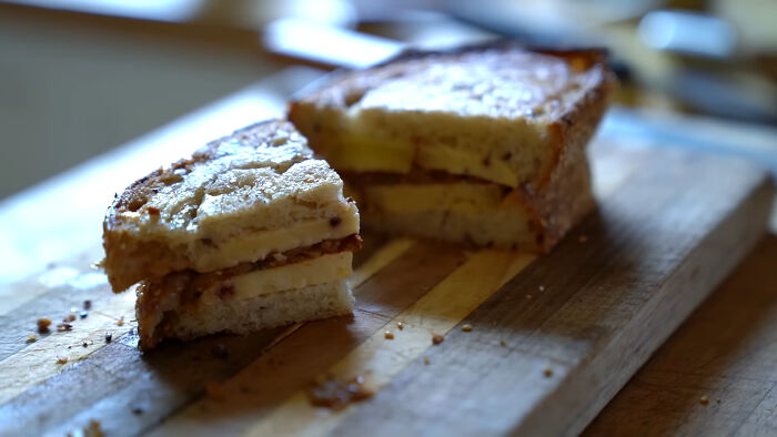 Sandwich with slices of apple on toasted bread on a wooden cutting board, featured in dishes that are just stupid.