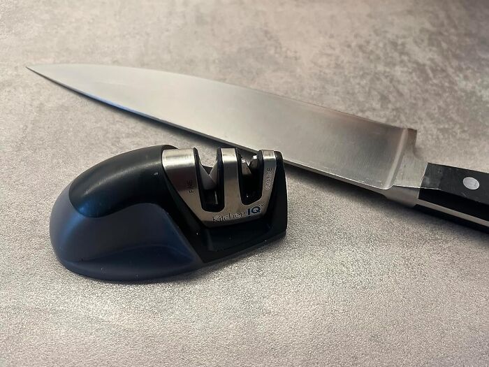Knife sharpener next to a kitchen knife on a countertop for cheapskate solutions.