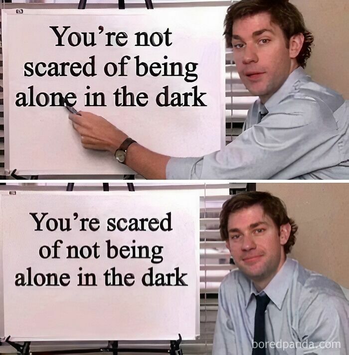 Man highlighting text on a flip chart with the caption about fear and darkness, in a humorous presentation setting.