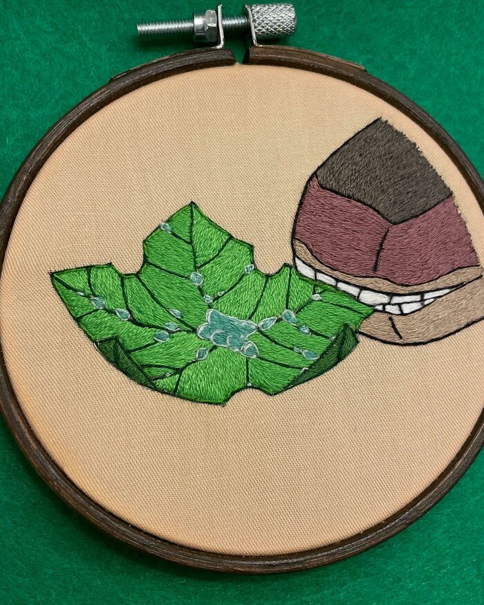 Embroidery hoop with detailed embroidered green leaf and spider design showcasing beautiful embroidery skills.