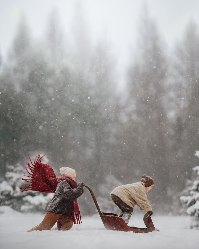 Children playing in the snow with a sled, capturing the magic of childhood in a snowy forest scene.