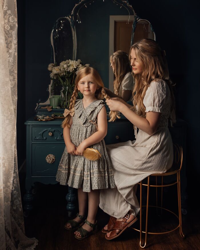 Mother braiding daughter’s hair in a vintage room, capturing the magic of childhood moments.
