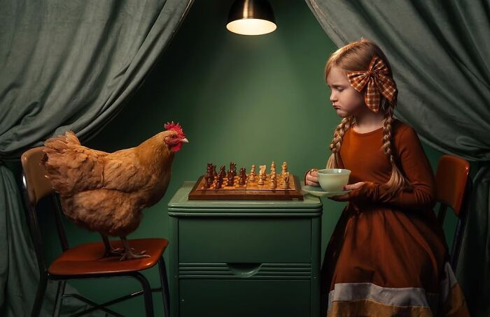 Girl playing chess with a chicken, capturing the magic of childhood through a creative lens.