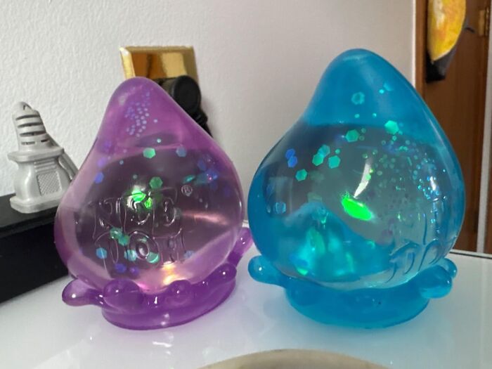 Two colorful blob-like TikTok-influenced decorations on a shelf.