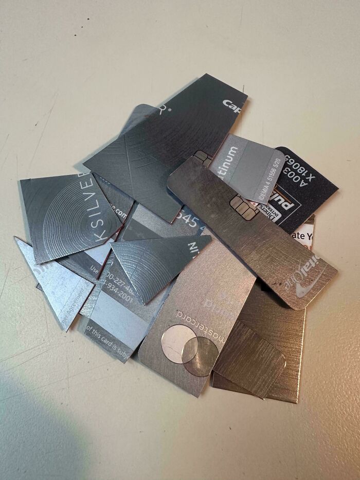 Cut up credit cards on a table highlighting issues of consumerism and financial waste in modern society.