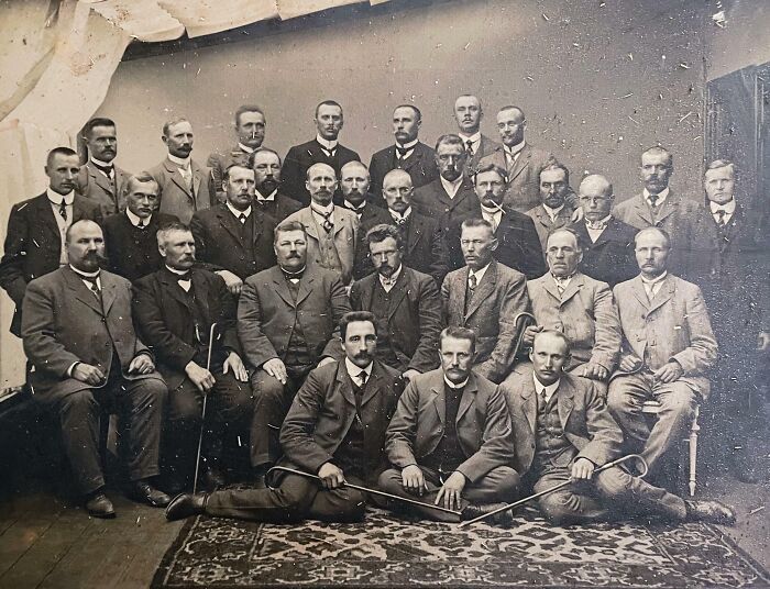 Group of men in formal attire from 50-100 years ago, posing for a rare historical photograph.