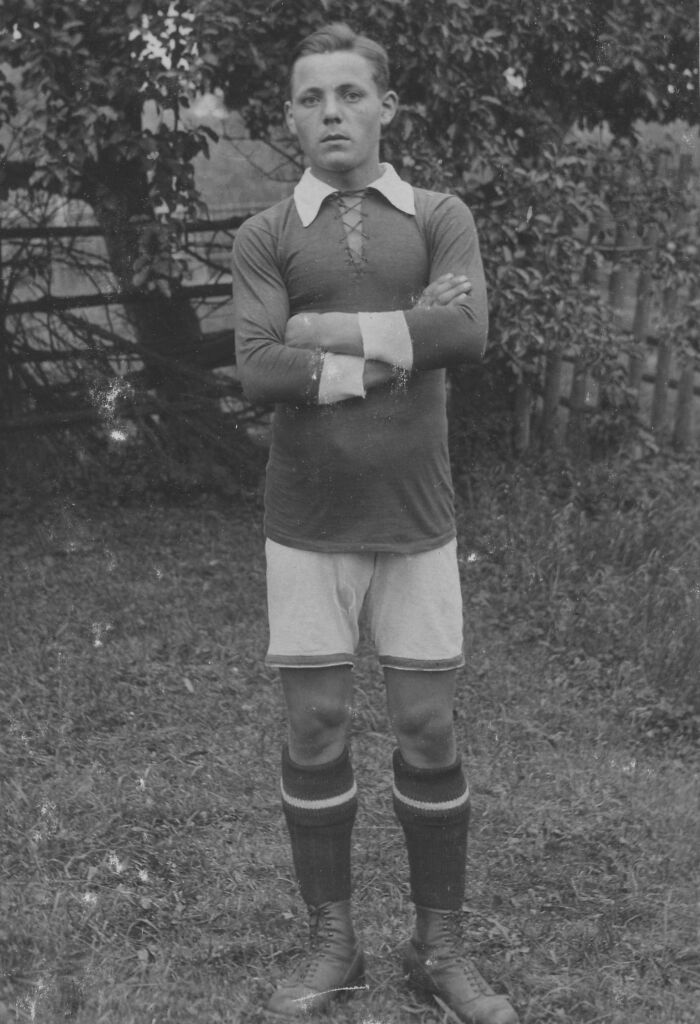 Young football player from early 20th century posing in vintage uniform, showcasing rare historical athletic fashion.