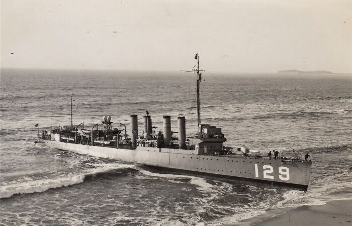 Historic naval ship 129 stranded on a sandy beach, illustrating how much the world has changed.