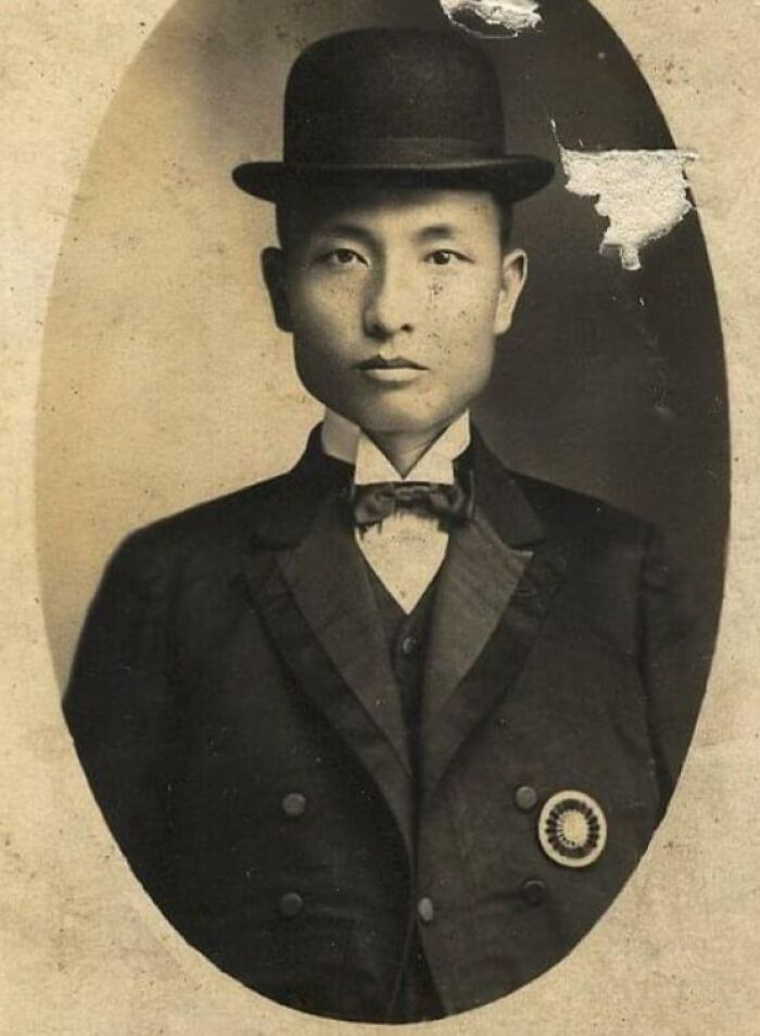A rare vintage photo of a man from 50-100 years ago wearing a suit and bowler hat, showing historical fashion.