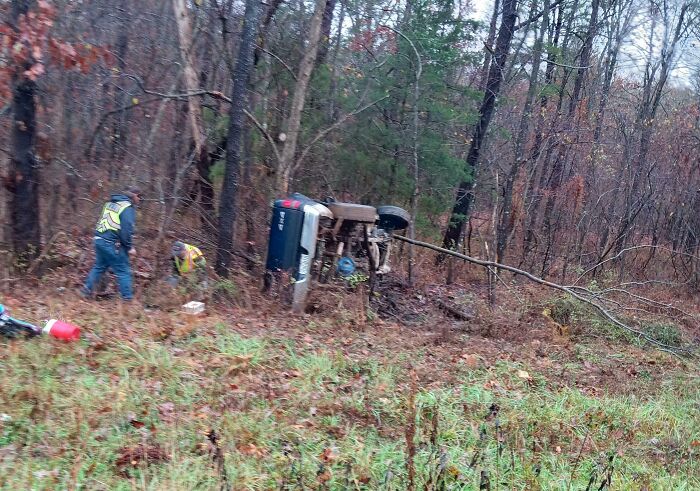 Overturned vehicle accident in a forested area, highlighting the aftermath of an expensive mishap.