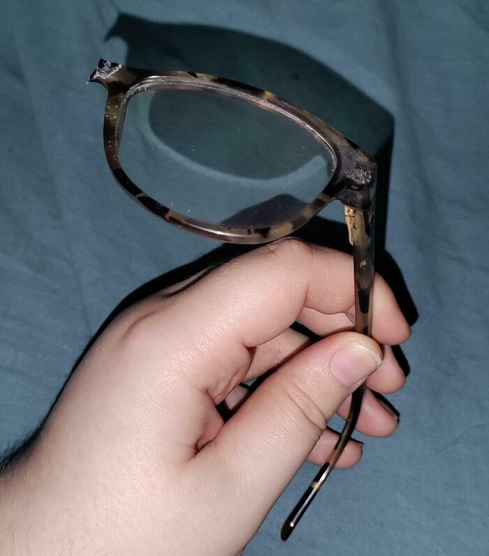 Broken glasses held in hand, highlighting an expensive accident aftermath.