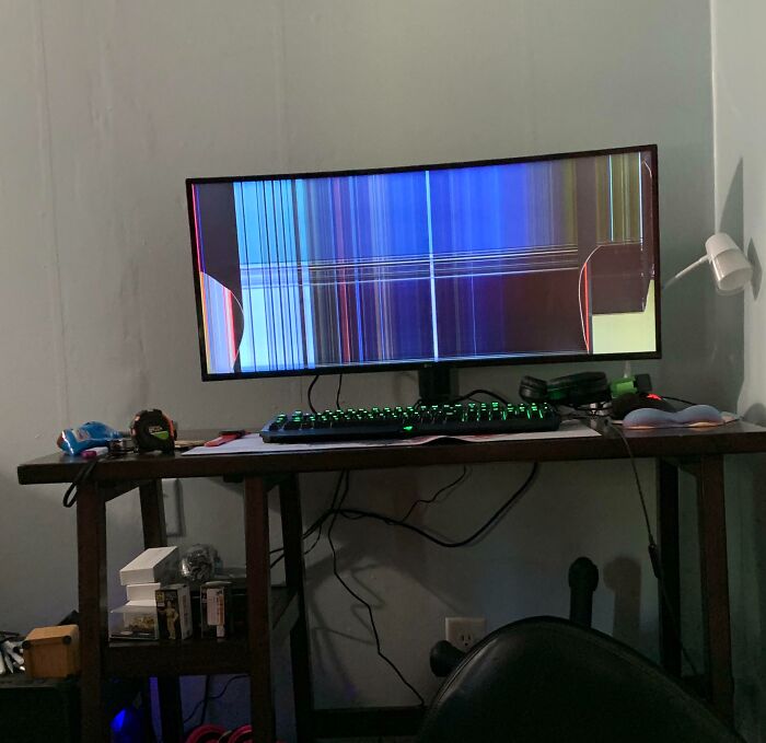 Broken computer monitor displaying colorful lines, showcasing an expensive accident.