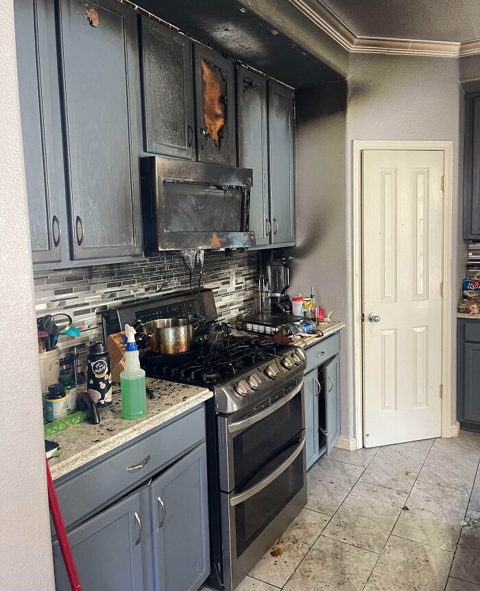 Kitchen fire aftermath with damaged cabinets and soot, illustrating expensive accidents.