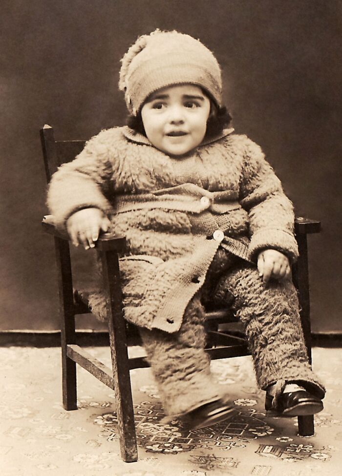 A vintage photo of a child in a fluffy outfit, highlighting historical fashion from 50-100 years ago.