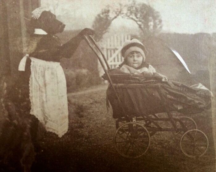 Vintage photo of a child in a stroller, pushed by a person in an animal costume, showcasing how the world has changed.
